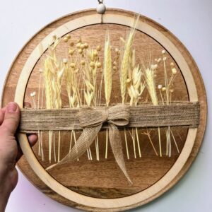 Ręcznie wykonany wianek boho z wysuszonych traw i zbóż na drewnianym kole z jutową wstążką.