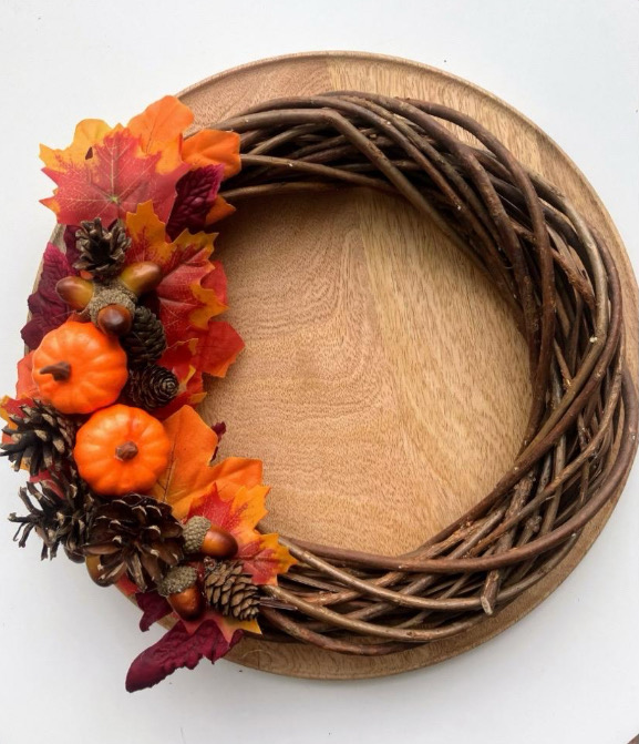 Ręcznie wykonany wianek jesienny o średnicy 30 cm, ozdobiony miniaturkami dyni, szyszek, żołędzi i klonowych liści, w ciepłych, rustykalnych kolorach, idealny do dekoracji wnętrz na jesień.