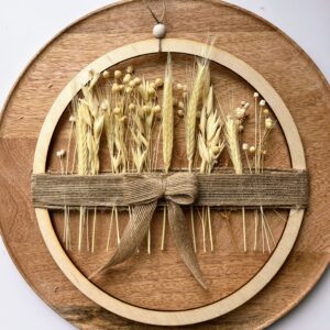 Ręcznie wykonany wianek boho z wysuszonych traw, zbóż i drewna, ozdobiony jutową wstążką – naturalna dekoracja ściany w stylu boho i slow life.