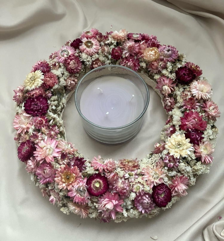 Ręcznie robiony wianek z suszonych kwiatów w odcieniach różu, kremu i magenty, ozdobiony delikatną koronką, ułożony na białym tle jako romantyczna dekoracja stołu, drzwi lub ściany.