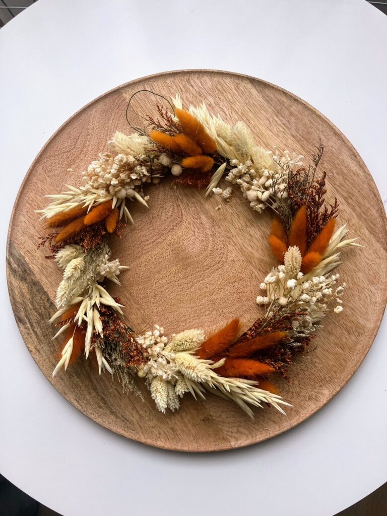 Ręcznie wykonany jesienny wianek boho z suszonych traw w odcieniach beżu i rudości na drewnianej sklejce, dekoracja na drzwi lub ścianę, idealny jako prezent lub jesienna ozdoba wnętrza.