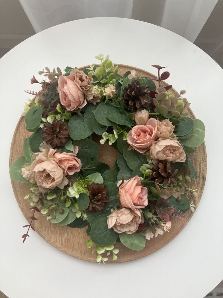 Ręcznie wykonany jesienny wianek z kwiatami w odcieniach różu i beżu, zielenią i szyszkami, dekoracja na drzwi, stół lub grób, elegancka i przytulna ozdoba sezonowa.