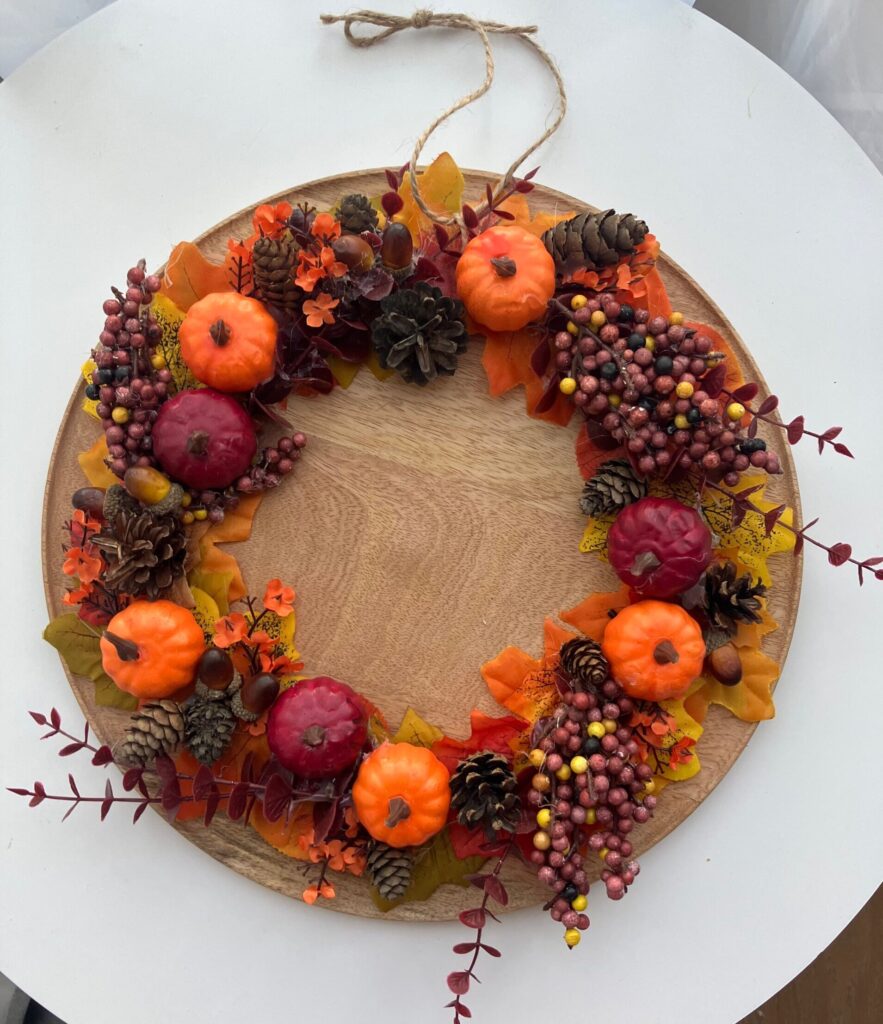 Jesienny wianek z dyniami w odcieniach borda i pomarańczu