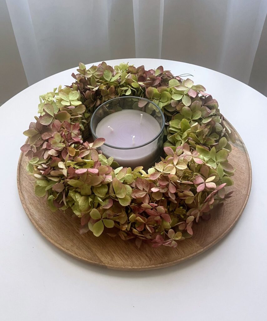 Ręcznie wykonany wianek z suszonej hortensji na naturalnej słomianej bazie to elegancka i trwała dekoracja do domu. Idealny jako wianek na drzwi, dekoracja ścienna, ozdoba stołu lub prezent. Delikatne kwiaty suszą się naturalnie, zachowując piękny kolor i rustykalny, boho styl.