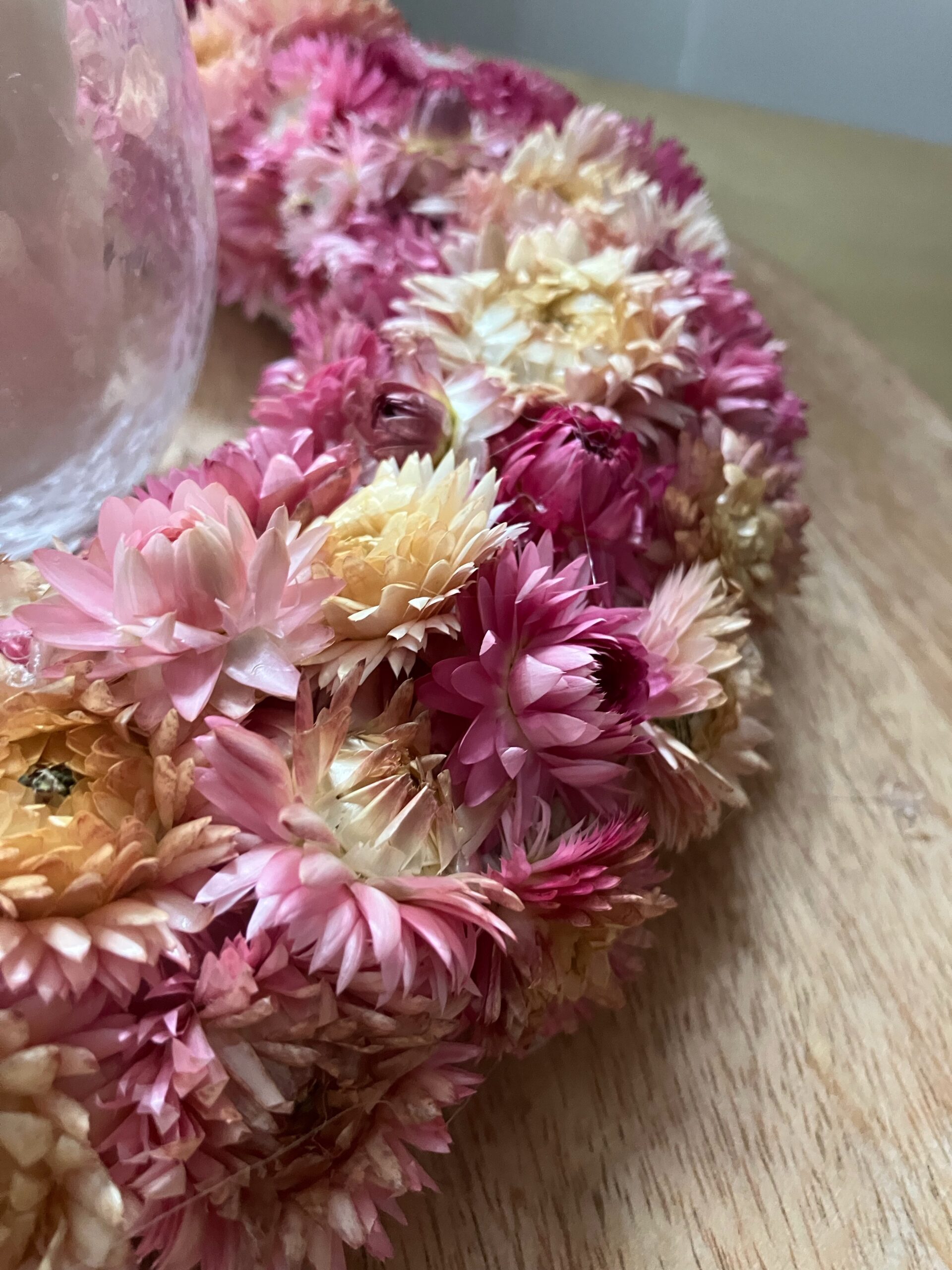 Dekoracyjny wianek ścienny z suszonych kwiatów i koronki