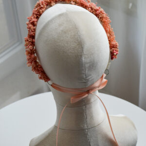 Zbliżenie na różowy wianek z gipsówki z regulowaną wstążką.